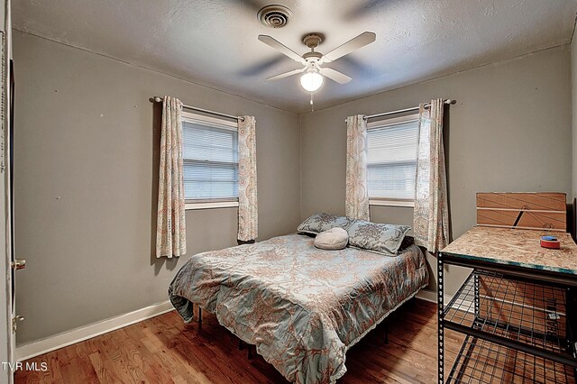 bedroom featuring a textured ceiling, ceiling fan, and hardwood / wood-style flooring