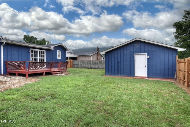 view of yard featuring a wooden deck, a fenced backyard, and an outdoor structure