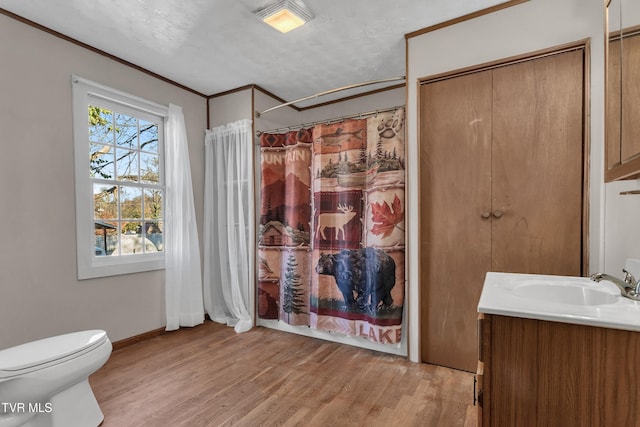 full bathroom featuring crown molding, vanity, shower / bath combo, hardwood / wood-style flooring, and toilet