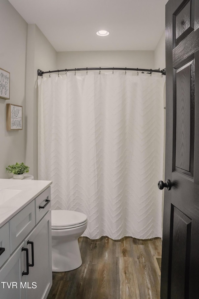 bathroom with vanity, hardwood / wood-style floors, and toilet