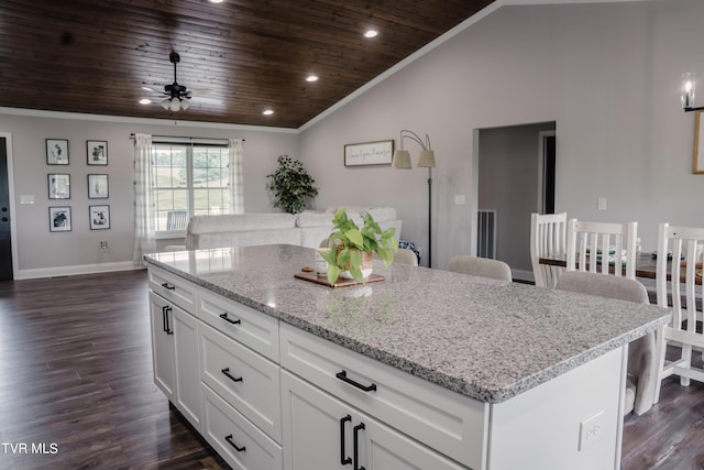 kitchen featuring vaulted ceiling, a kitchen island, white cabinetry, a kitchen bar, and wooden ceiling