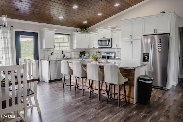 kitchen featuring a center island, vaulted ceiling, wooden ceiling, stainless steel appliances, and white cabinets