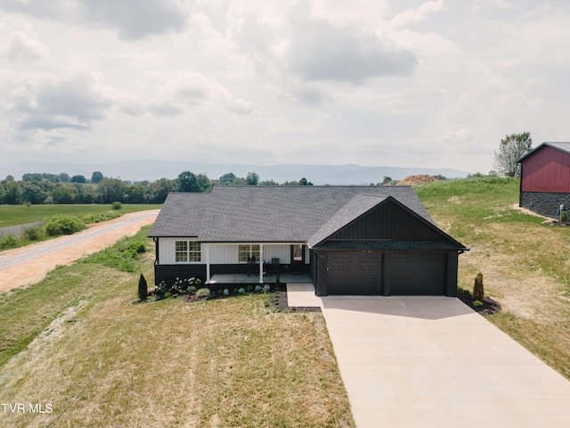 single story home featuring a porch, a garage, and a front lawn