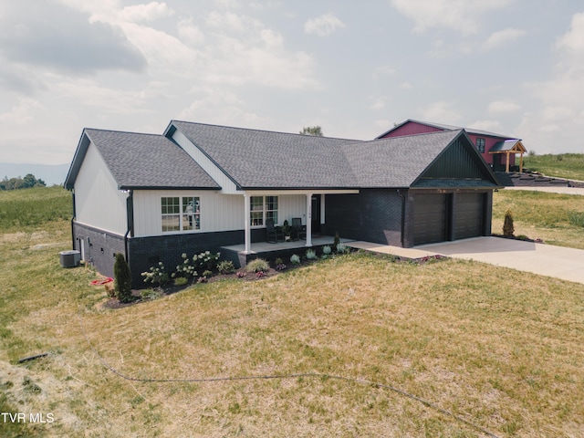 ranch-style house featuring cooling unit, a garage, a front lawn, and covered porch