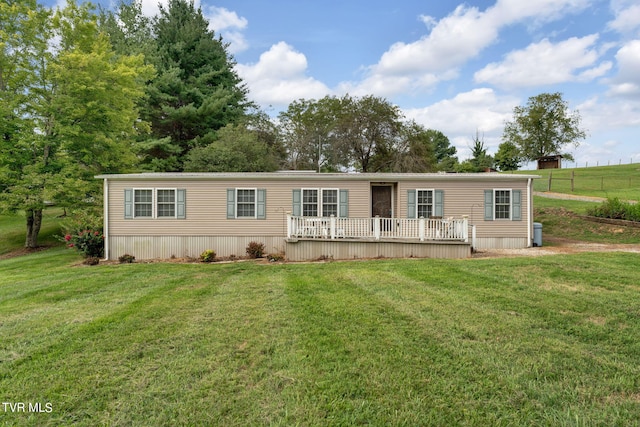 manufactured / mobile home featuring a deck and a front lawn