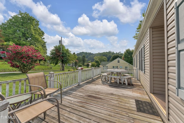 deck with a yard and outdoor dining space