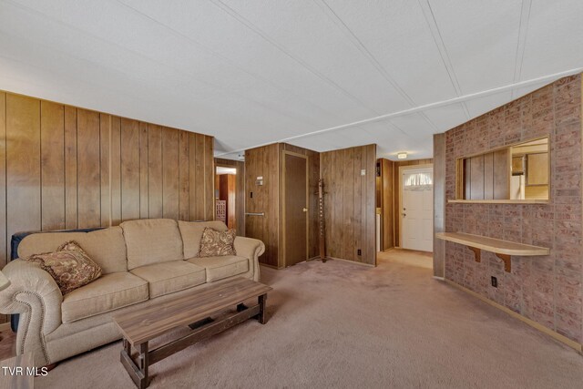 carpeted living room featuring wood walls and brick wall