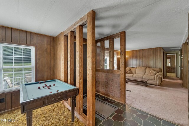 game room featuring carpet floors, pool table, a textured ceiling, and wood walls