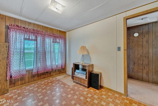 interior space featuring wooden walls and a textured ceiling