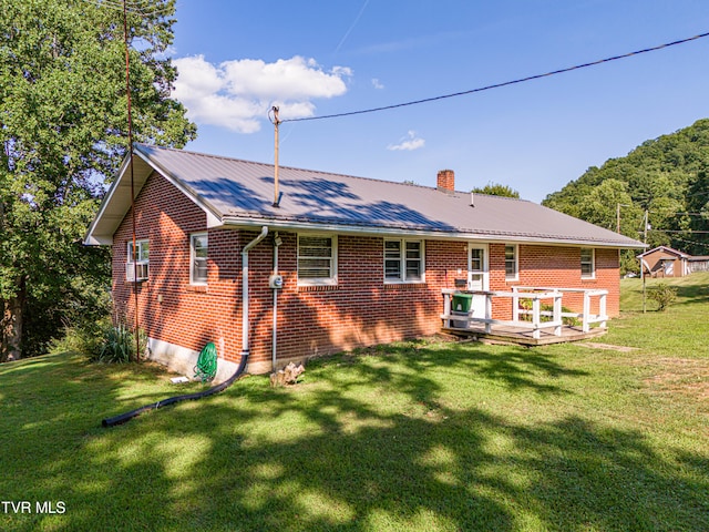 back of house featuring a wooden deck and a yard