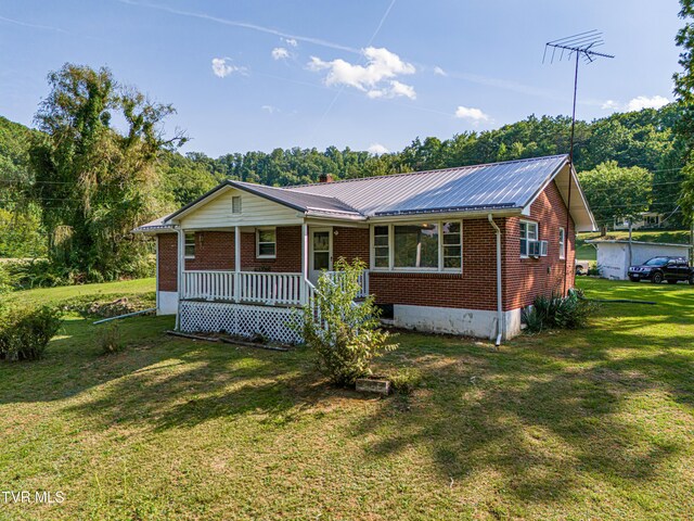 ranch-style home with covered porch and a front lawn