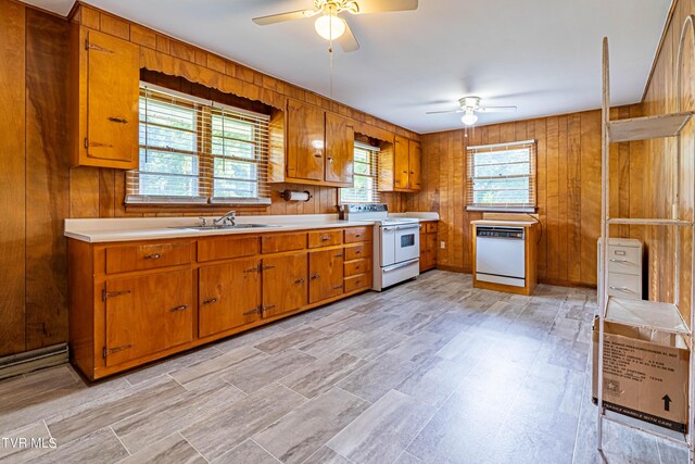 kitchen featuring ceiling fan, wooden walls, sink, and white appliances