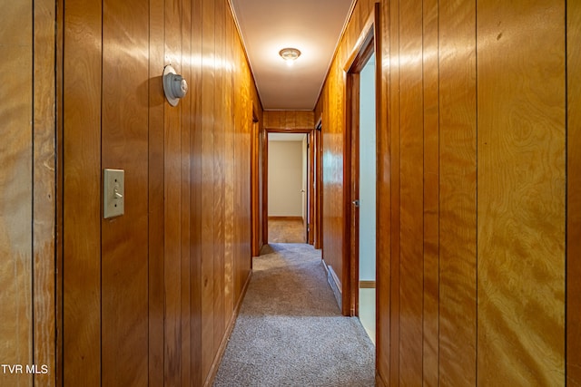 hallway with carpet floors and wooden walls