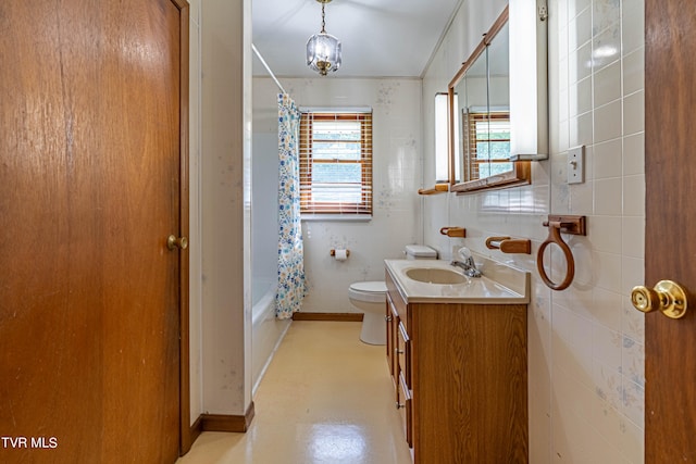 full bathroom with shower / bath combination with curtain, toilet, vanity, and tile walls