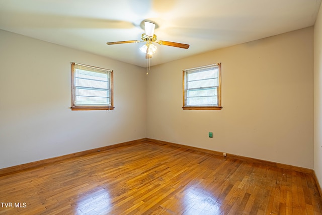 empty room with ceiling fan, plenty of natural light, and light hardwood / wood-style floors