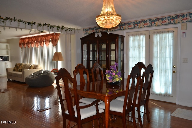 dining room featuring wood-type flooring, plenty of natural light, a chandelier, and crown molding