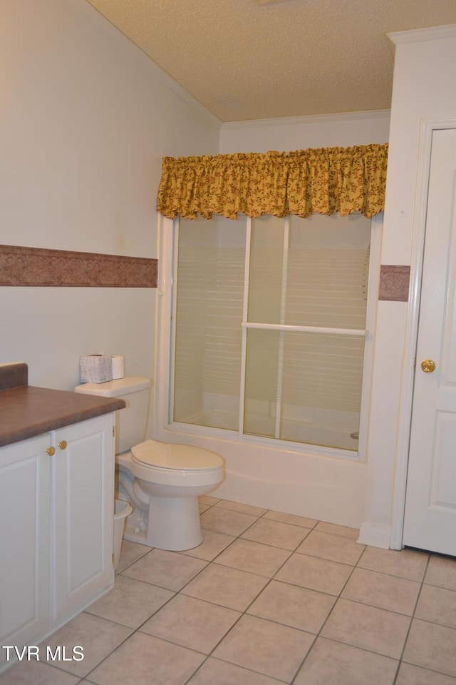 full bathroom featuring toilet, tile patterned floors, a textured ceiling, combined bath / shower with glass door, and vanity