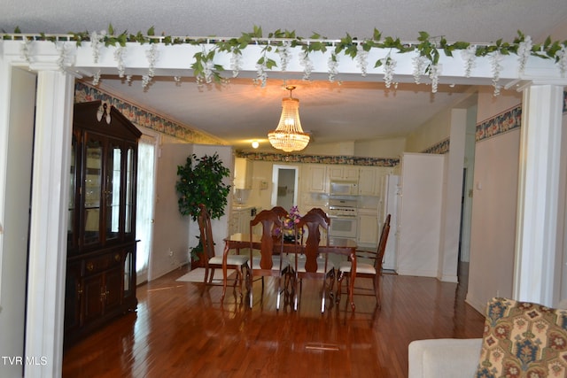 dining space featuring wood-type flooring, a textured ceiling, a chandelier, and lofted ceiling