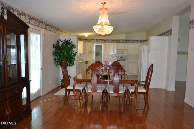 dining space featuring an inviting chandelier, lofted ceiling, and wood-type flooring