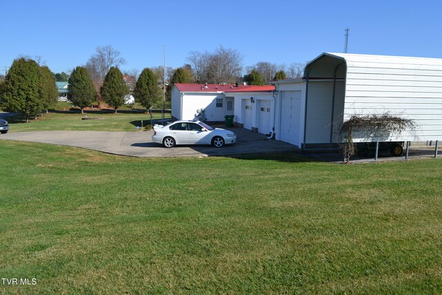 view of parking featuring a yard and a carport