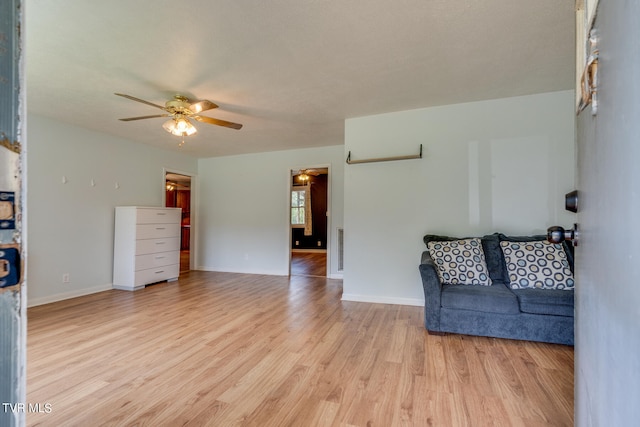 living room with ceiling fan and light hardwood / wood-style flooring