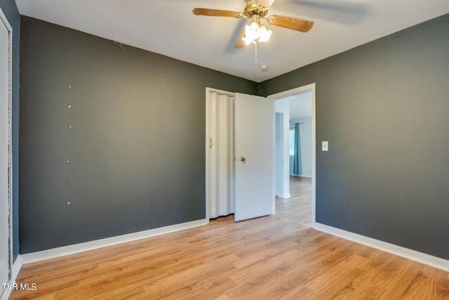 empty room with ceiling fan and light hardwood / wood-style floors