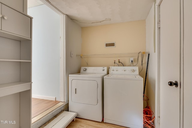 washroom with light hardwood / wood-style floors and independent washer and dryer