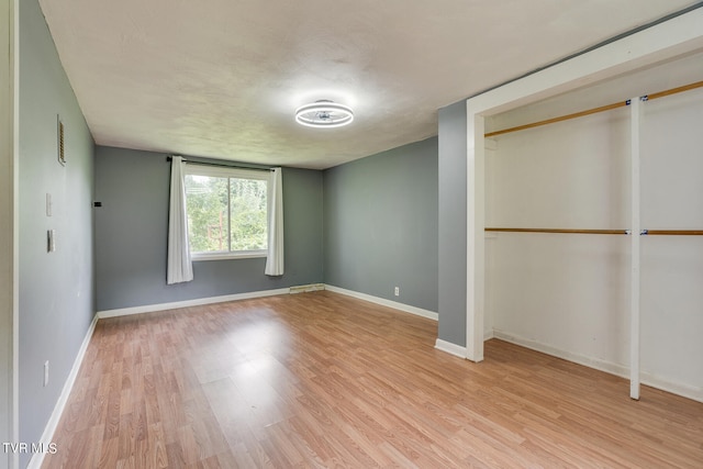 unfurnished bedroom with light hardwood / wood-style flooring and a closet