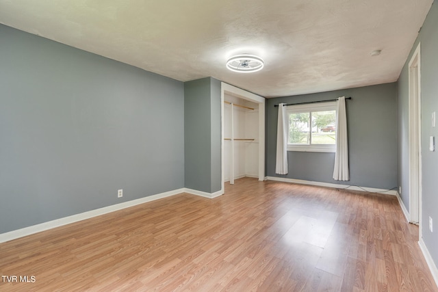 unfurnished bedroom with light hardwood / wood-style flooring and a closet