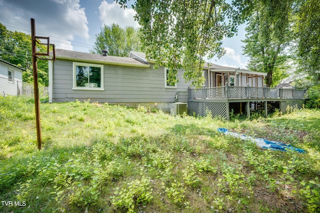 back of property with central AC unit and a wooden deck