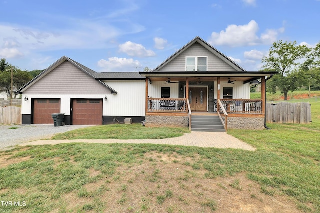 view of front of house with a garage, a porch, a front lawn, and fence