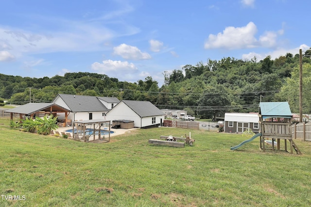 view of yard with a patio area, a playground, and fence