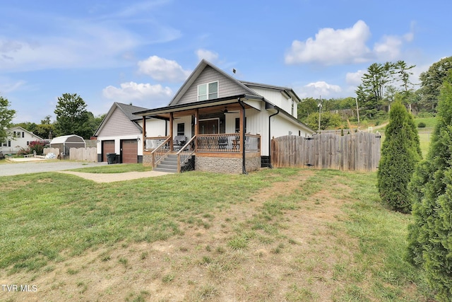 view of front of house with driveway, covered porch, fence, and a front yard