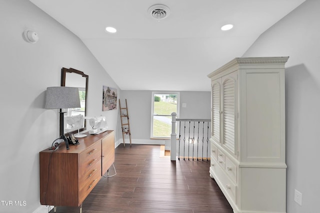 hall featuring dark wood-style flooring, lofted ceiling, visible vents, an upstairs landing, and baseboards