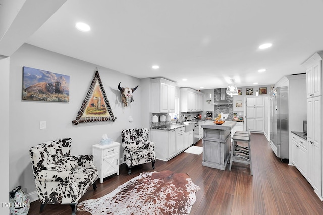 kitchen with dark wood-style flooring, white cabinets, a kitchen island, and a breakfast bar area