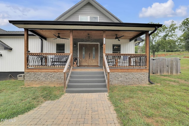 bungalow featuring a porch, a front lawn, and a ceiling fan