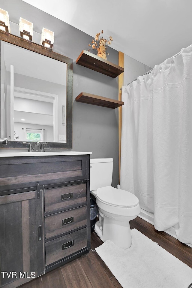 bathroom with toilet, wood finished floors, and vanity