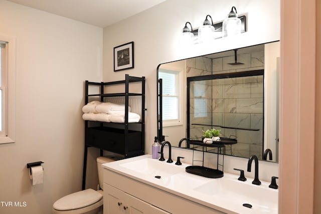 bathroom featuring dual bowl vanity and toilet