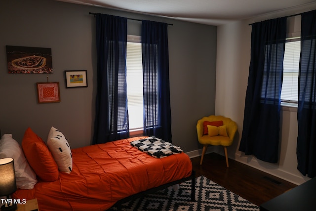 bedroom with wood-type flooring and multiple windows