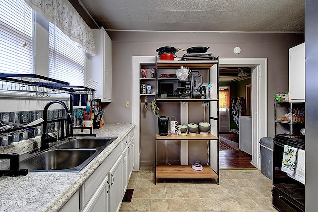 kitchen featuring white cabinetry, sink, and light stone counters