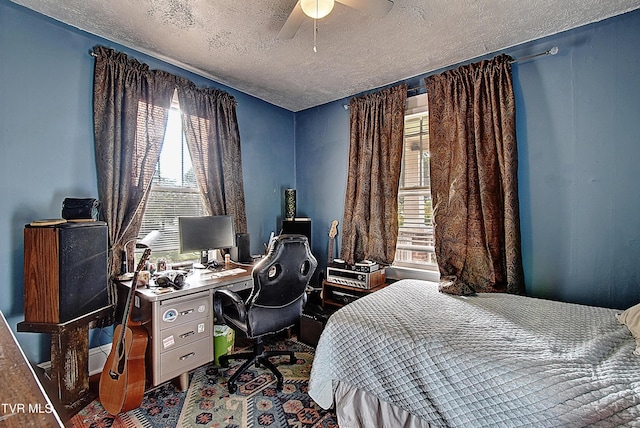 bedroom with ceiling fan and a textured ceiling