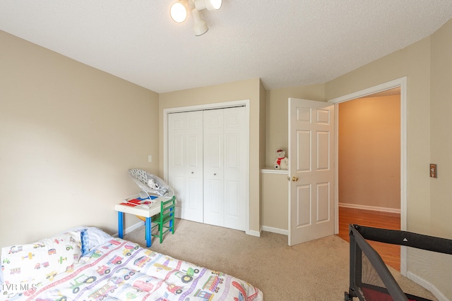 carpeted bedroom with a closet and a textured ceiling