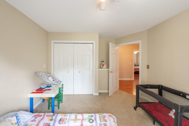 bedroom with a closet, a textured ceiling, and light hardwood / wood-style floors