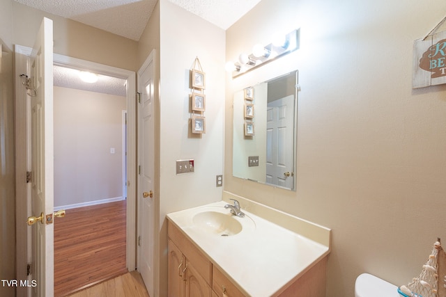 bathroom featuring a textured ceiling, vanity, and wood-type flooring