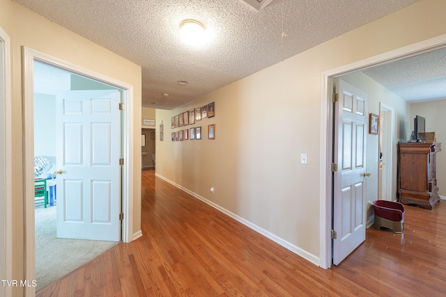 hallway featuring carpet and a textured ceiling