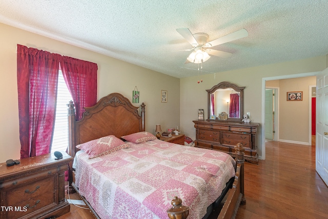 bedroom with a textured ceiling, ceiling fan, and wood-type flooring