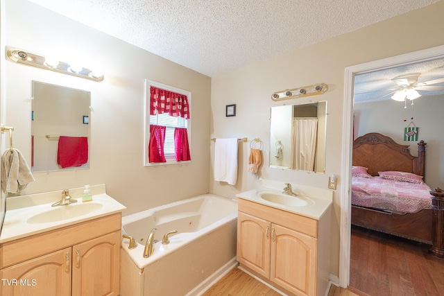 bathroom featuring hardwood / wood-style floors, a bathing tub, a textured ceiling, and ceiling fan