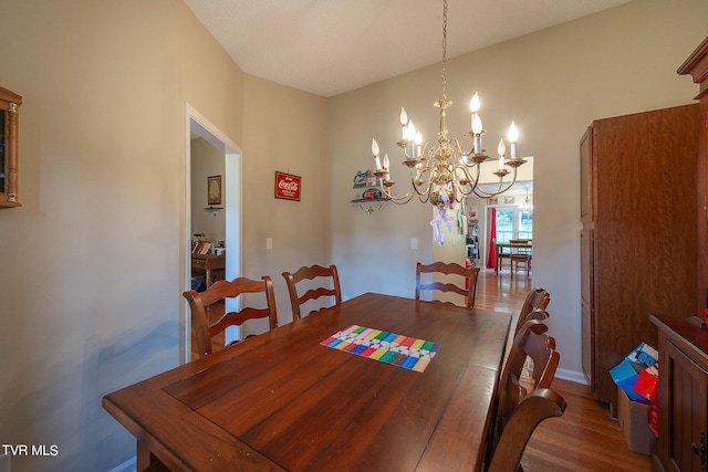 dining space with wood-type flooring and a notable chandelier