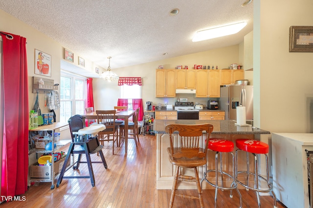 kitchen with light hardwood / wood-style flooring, electric stove, light brown cabinets, lofted ceiling, and stainless steel fridge with ice dispenser