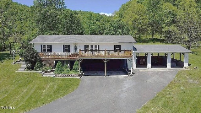 view of front of home featuring a garage, a front lawn, a carport, and covered porch